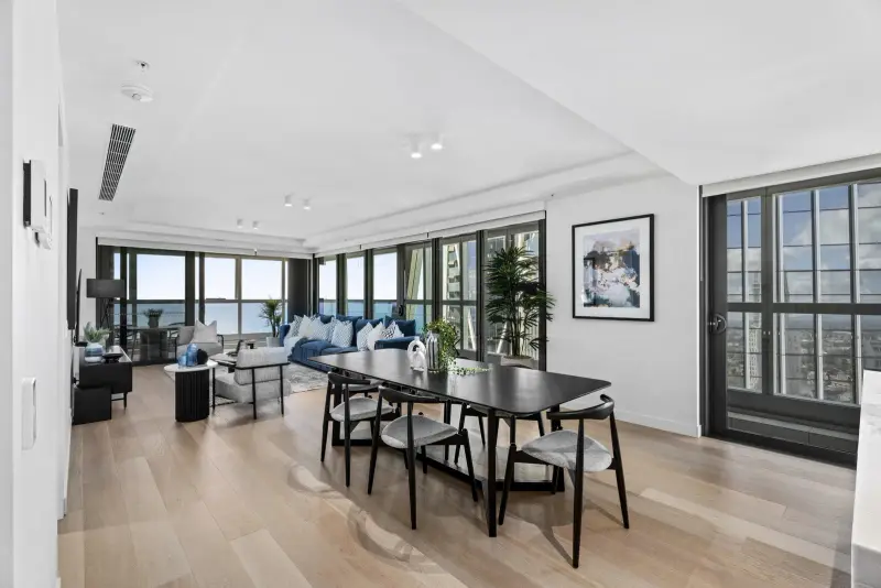 Jewel Residences open-plan living and dining with ocean views, black dining setting and blue sofa