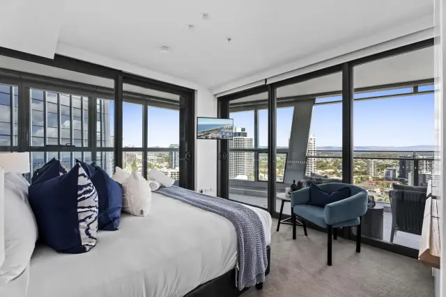 Bedroom with navy cushions and teal armchair overlooking Gold Coast hinterland