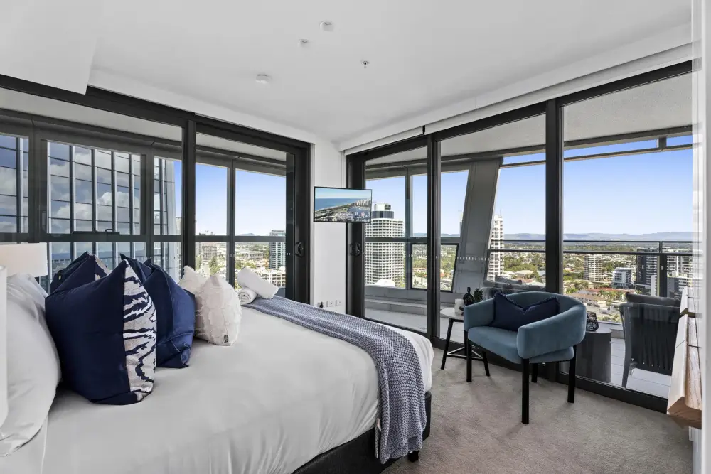 Bedroom with navy cushions and teal armchair overlooking Gold Coast hinterland