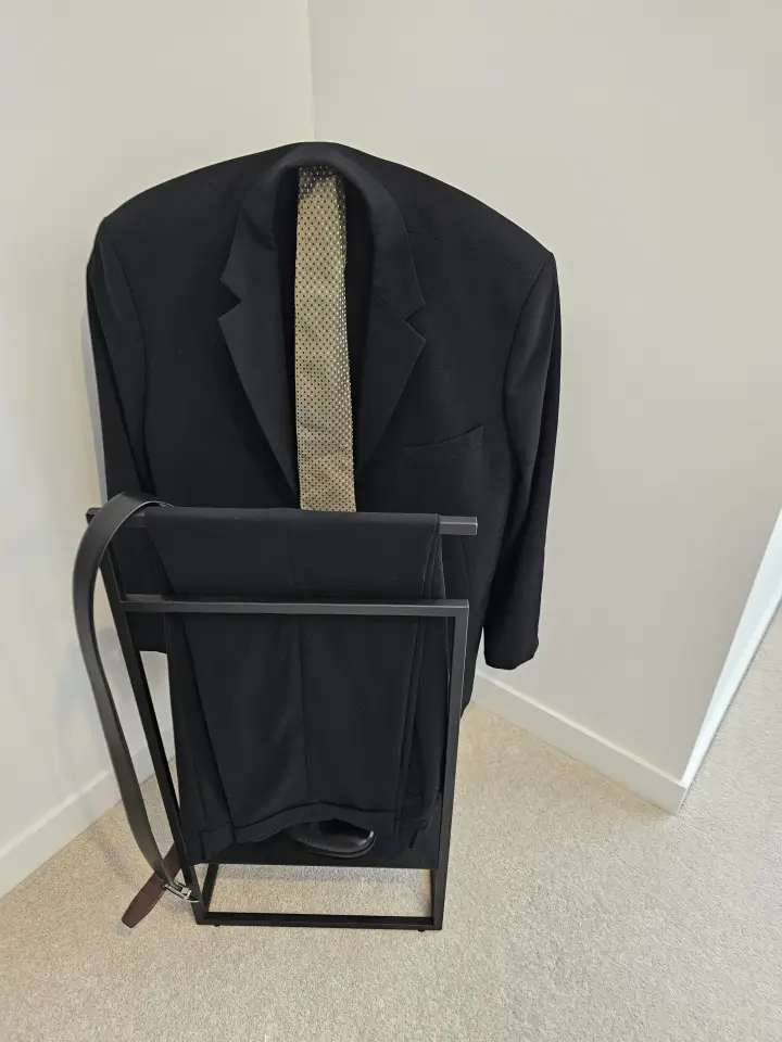 Bedroom detail with black valet stand and tailored suit