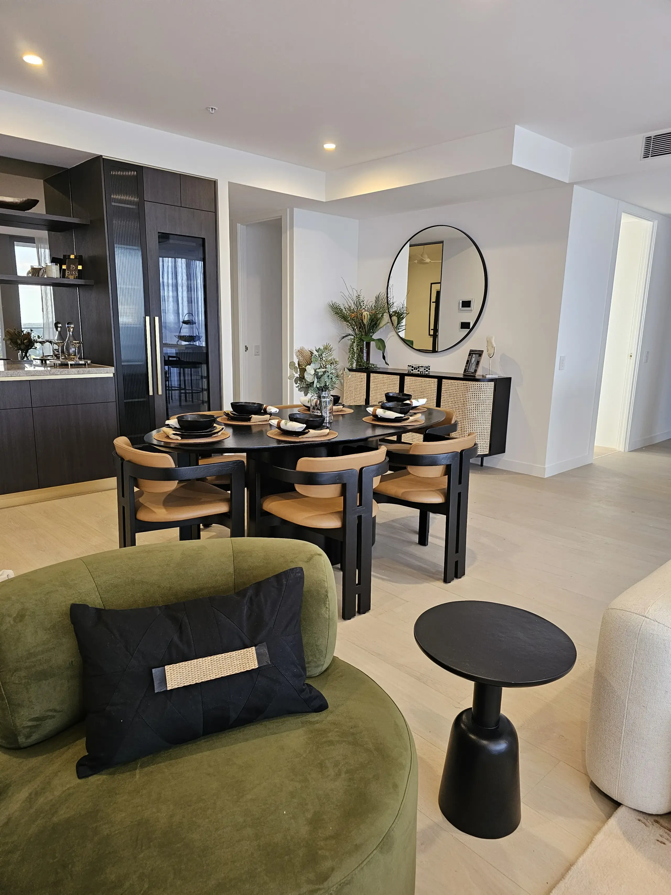 Remi display suite with olive armchair, black dining setting and dark butler's pantry