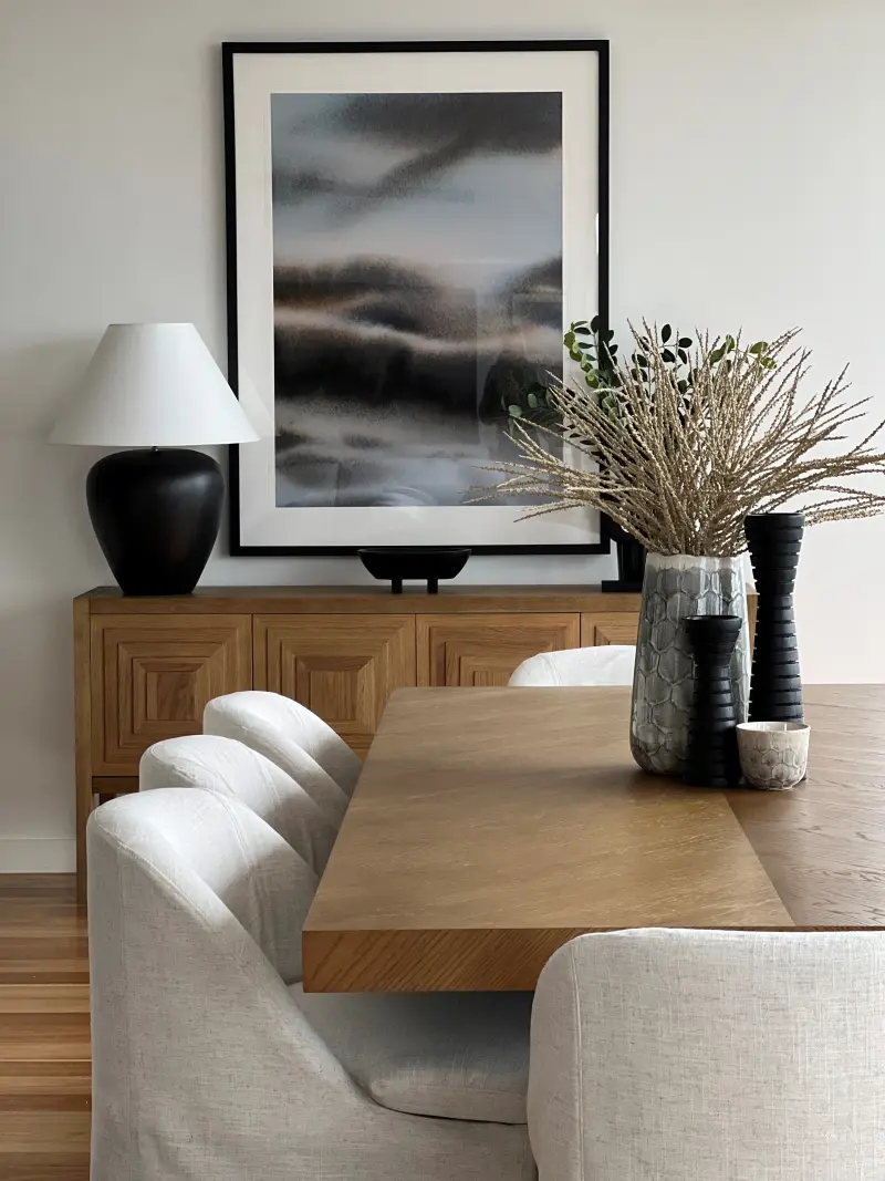Mount Martha dining area with oak table, cream upholstered chairs and moody landscape artwork