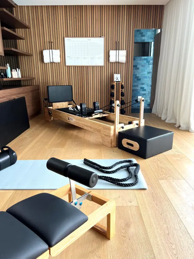 Home pilates studio with timber reformer, slatted timber feature wall and oak flooring
