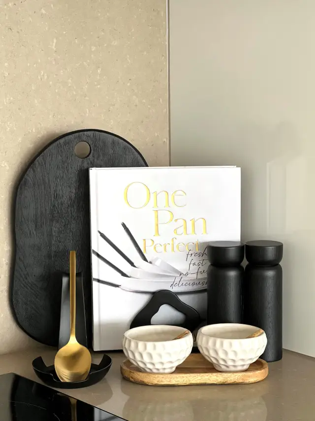 Kitchen styling with black board, cookbook, brass spoon rest and textured pinch bowls