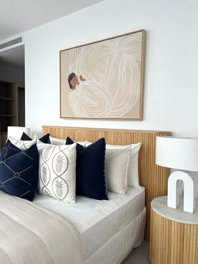 Master bedroom detail with fluted oak bedside and linen bedding