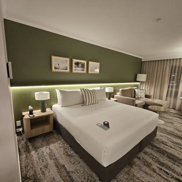 King room with a taupe modular sofa, framed black-and-white surf photography and coordinated soft furnishings