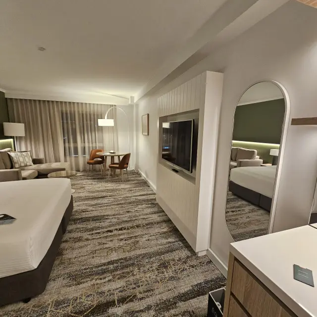 Guest room with a white-framed arched full-length mirror, dining setting and framed artwork