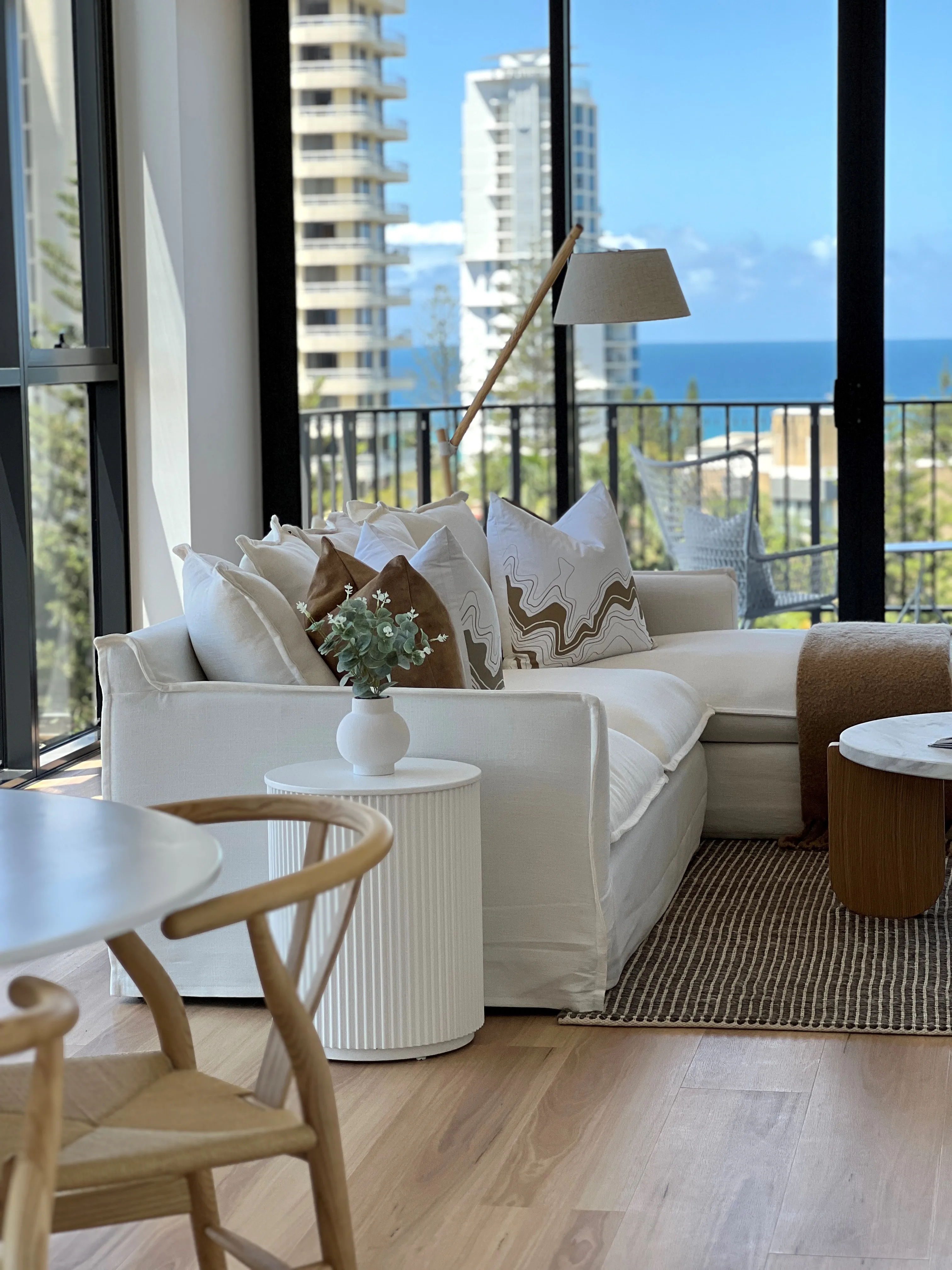 Malo display suite living area with cream sofa, earth-toned cushions and ocean views