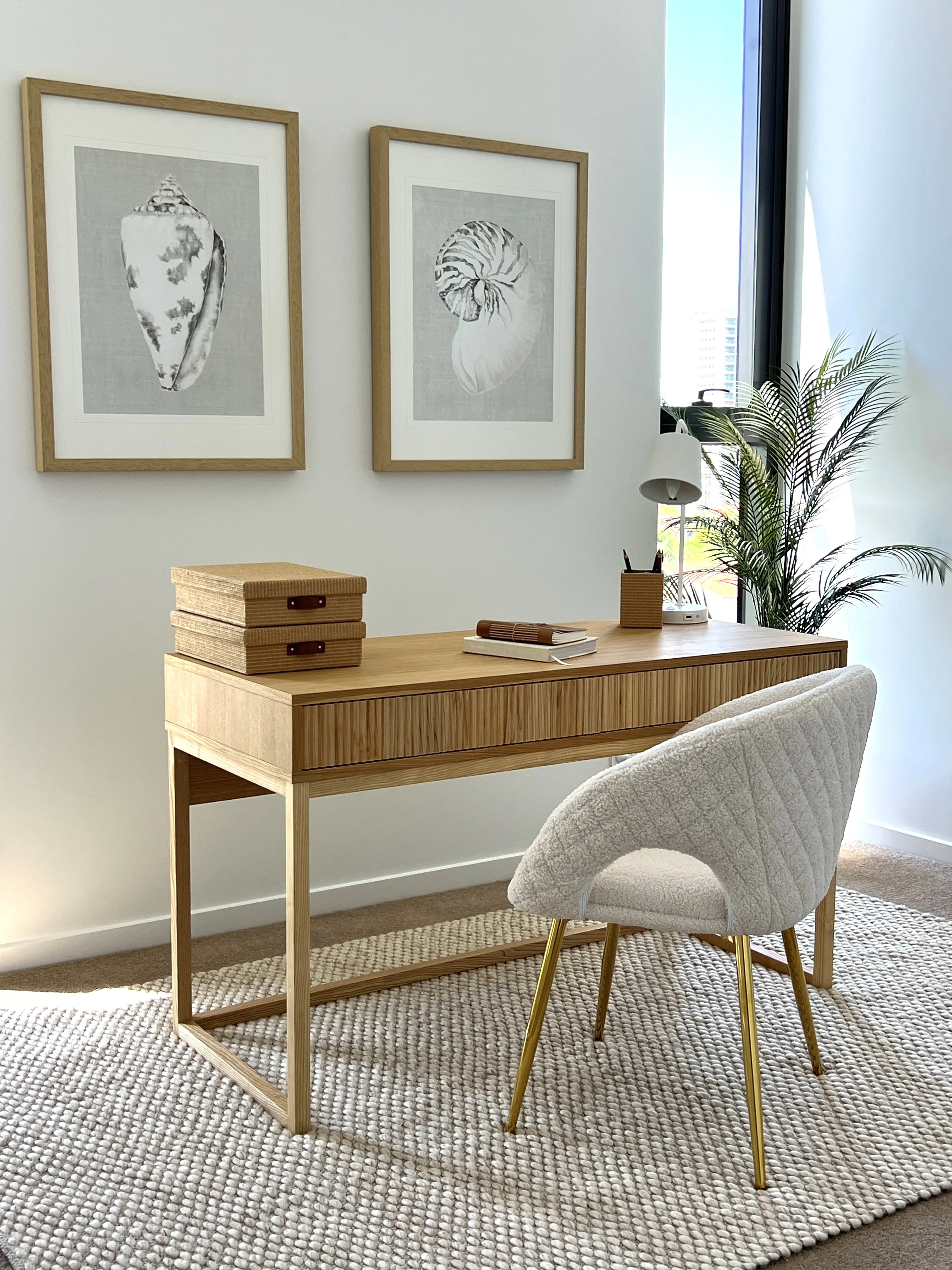 Study nook with fluted oak desk, quilted cream chair on brass legs and shell artwork diptych