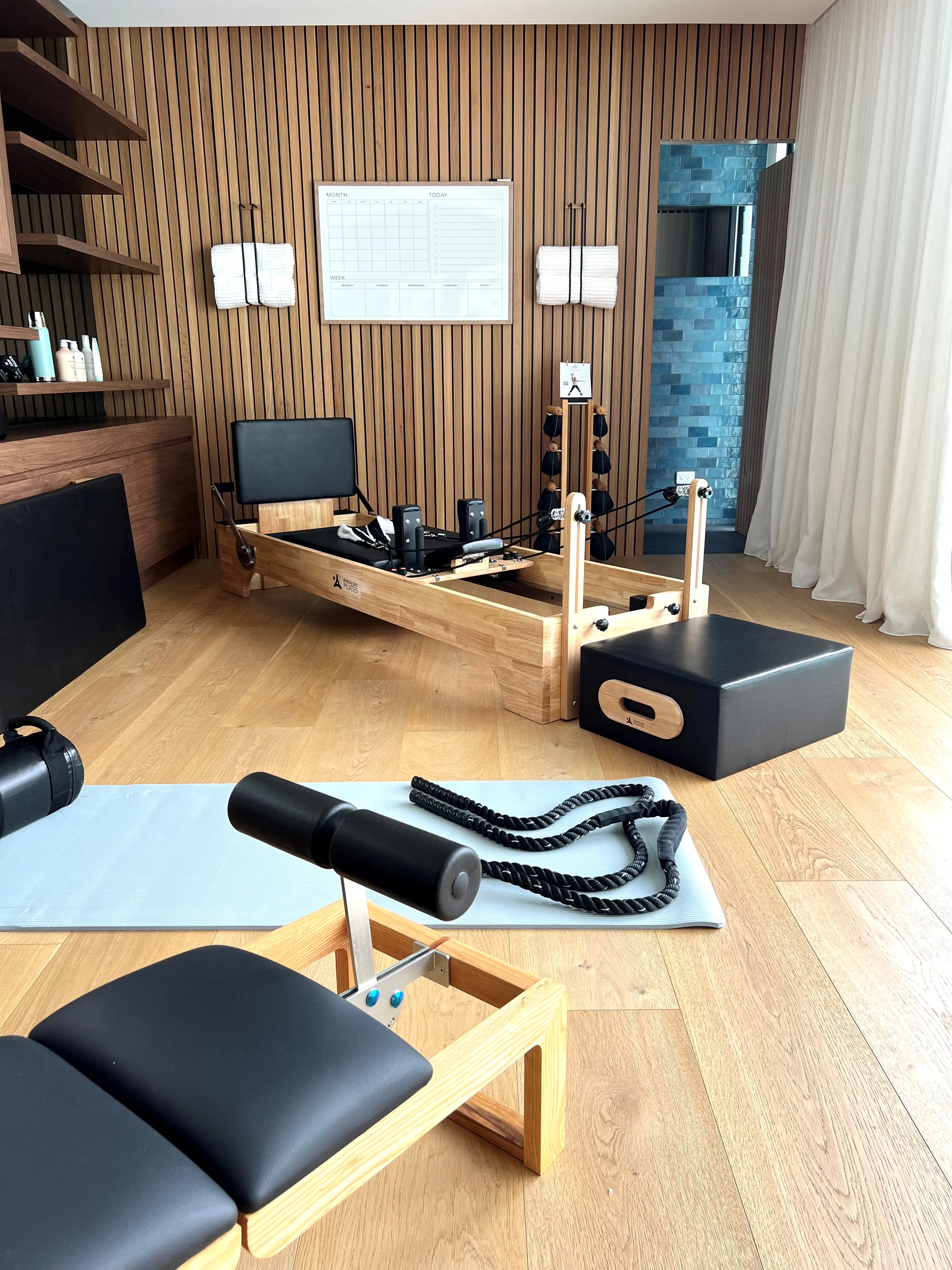 Home pilates studio with timber reformer, slatted timber feature wall and oak flooring