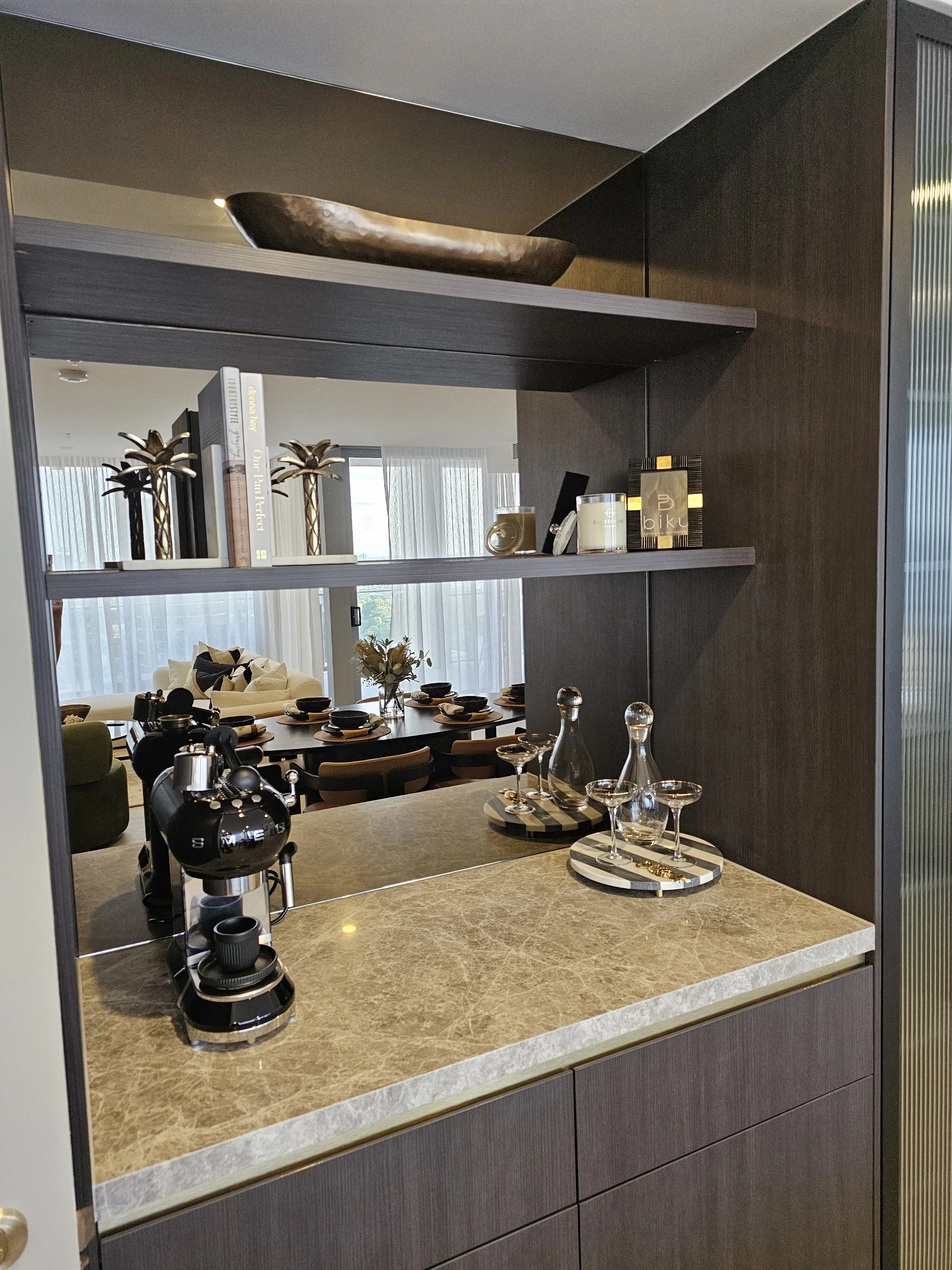 Dark butler's pantry with marble benchtop, mirrored splashback and espresso machine