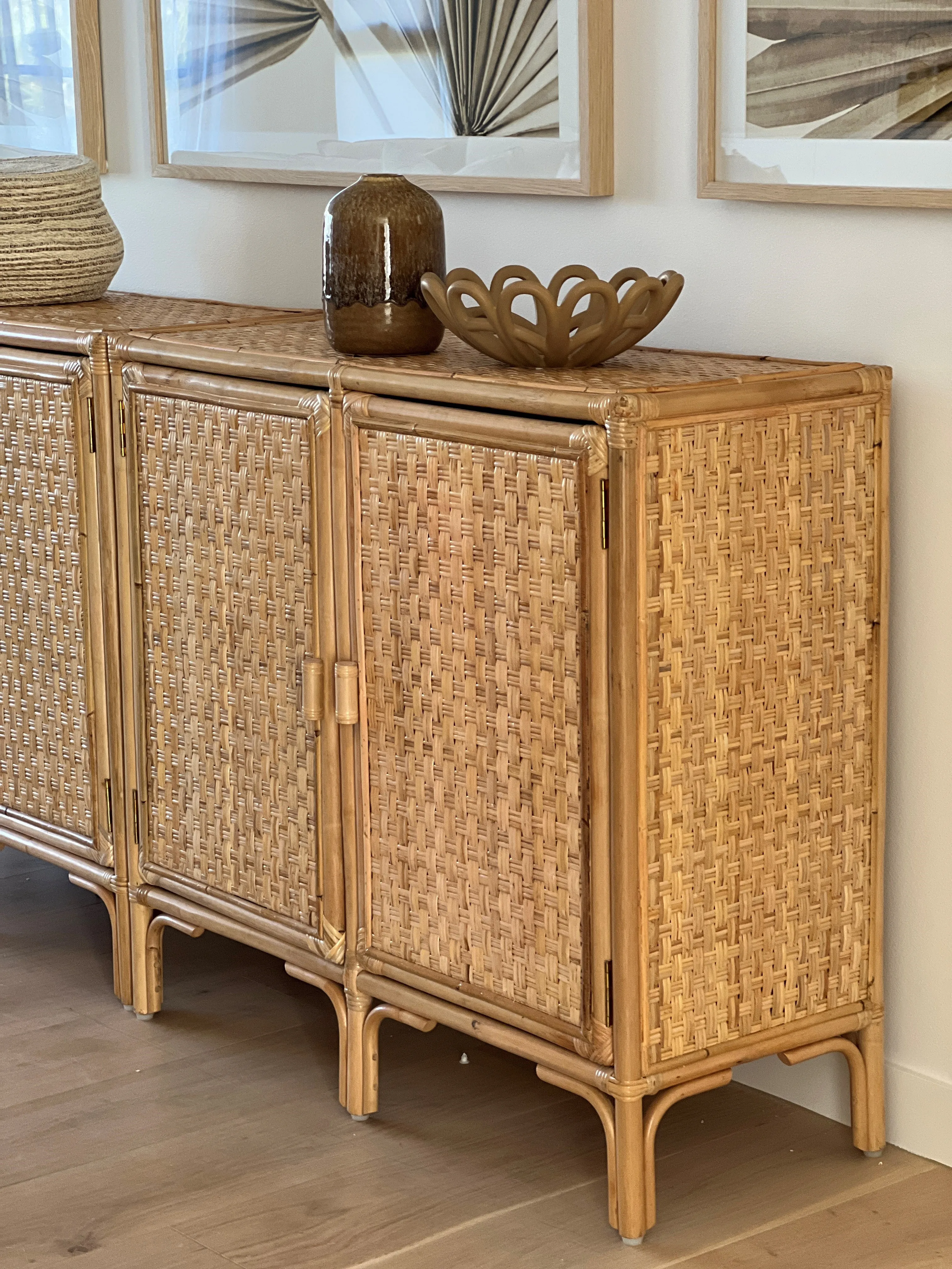 Rattan woven sideboard with botanical artwork and sculptural decor